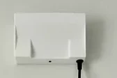 A NexaSense radar unit installed on a wall with its power cable connected.